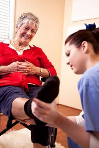 podiatrist assisting senior woman with foot pain