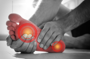 A photo of a person holding their foot due to foot pain.